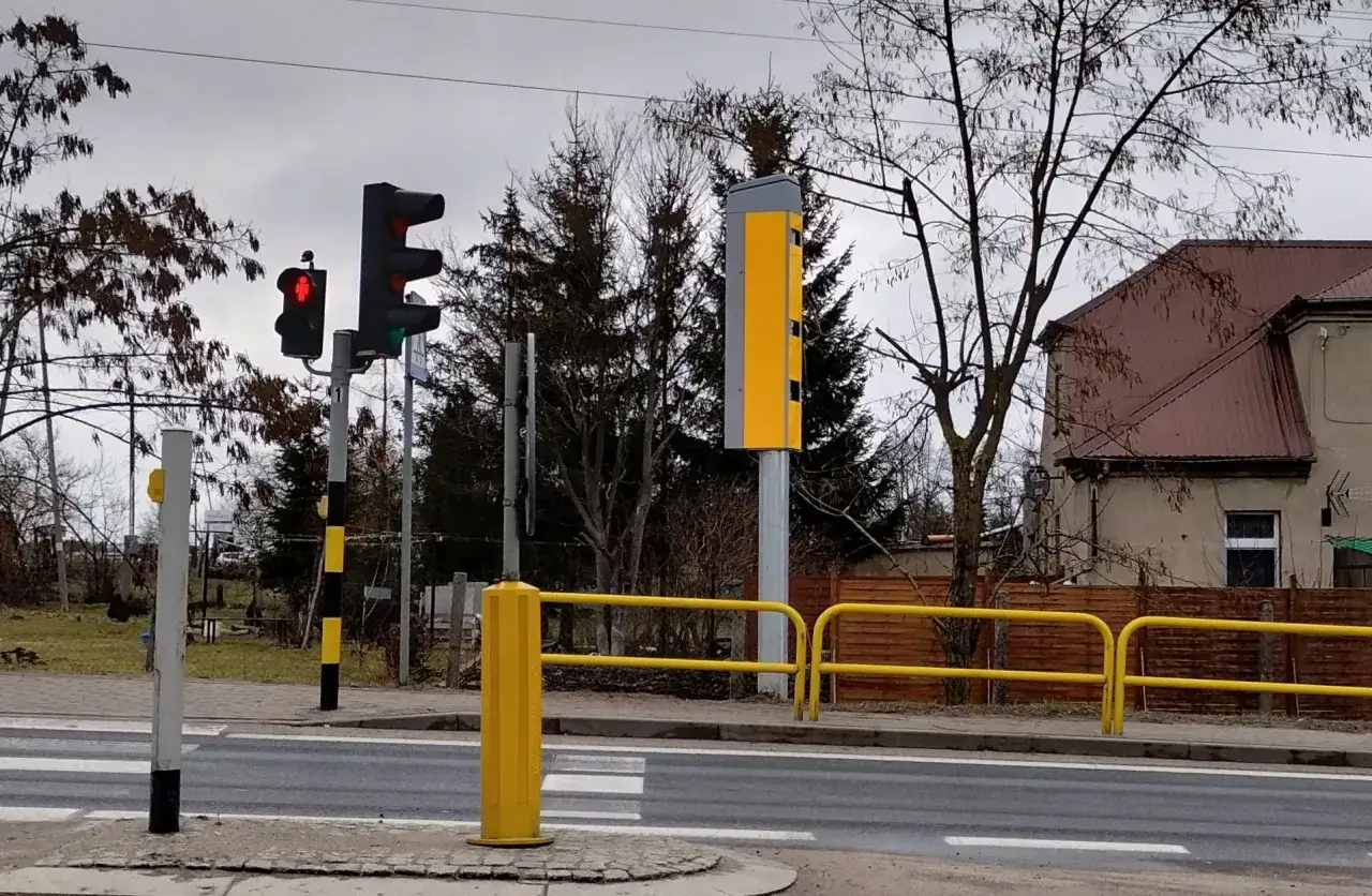 Fotoradar stoi blisko przejścia dla pieszych, gotowy do rejestrowania wykroczeń.