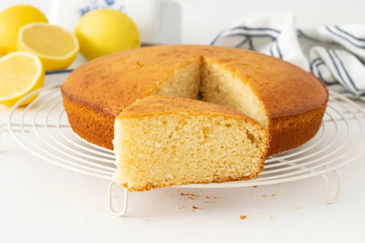 Bizcocho de lim&oacute;n esponjoso, perfecto para tu pr&oacute;xima receta. Limones frescos y un trozo cortado muestran su deliciosa textura.
