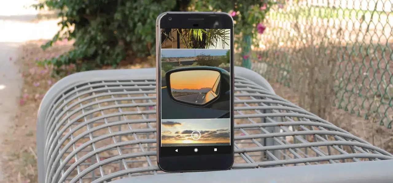 Un telefono Android mostra una galleria di foto in movimento: un tramonto visto dallo specchietto retrovisore e un altro al tramonto sul mare.