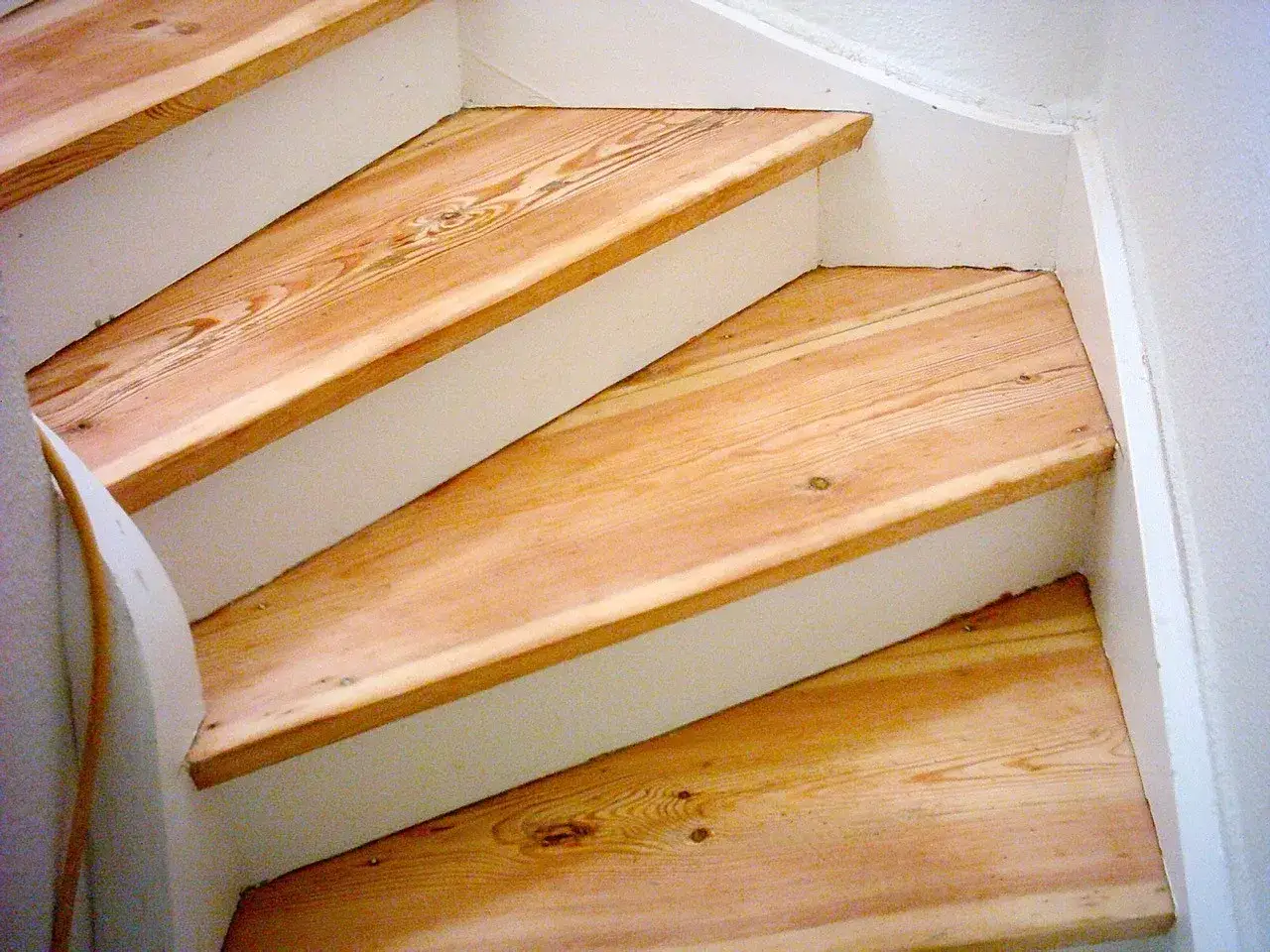 Holztreppe nach dem **Boden schleifen** mit hellem, nat&uuml;rlichem Holz und wei&szlig;en Wangen.