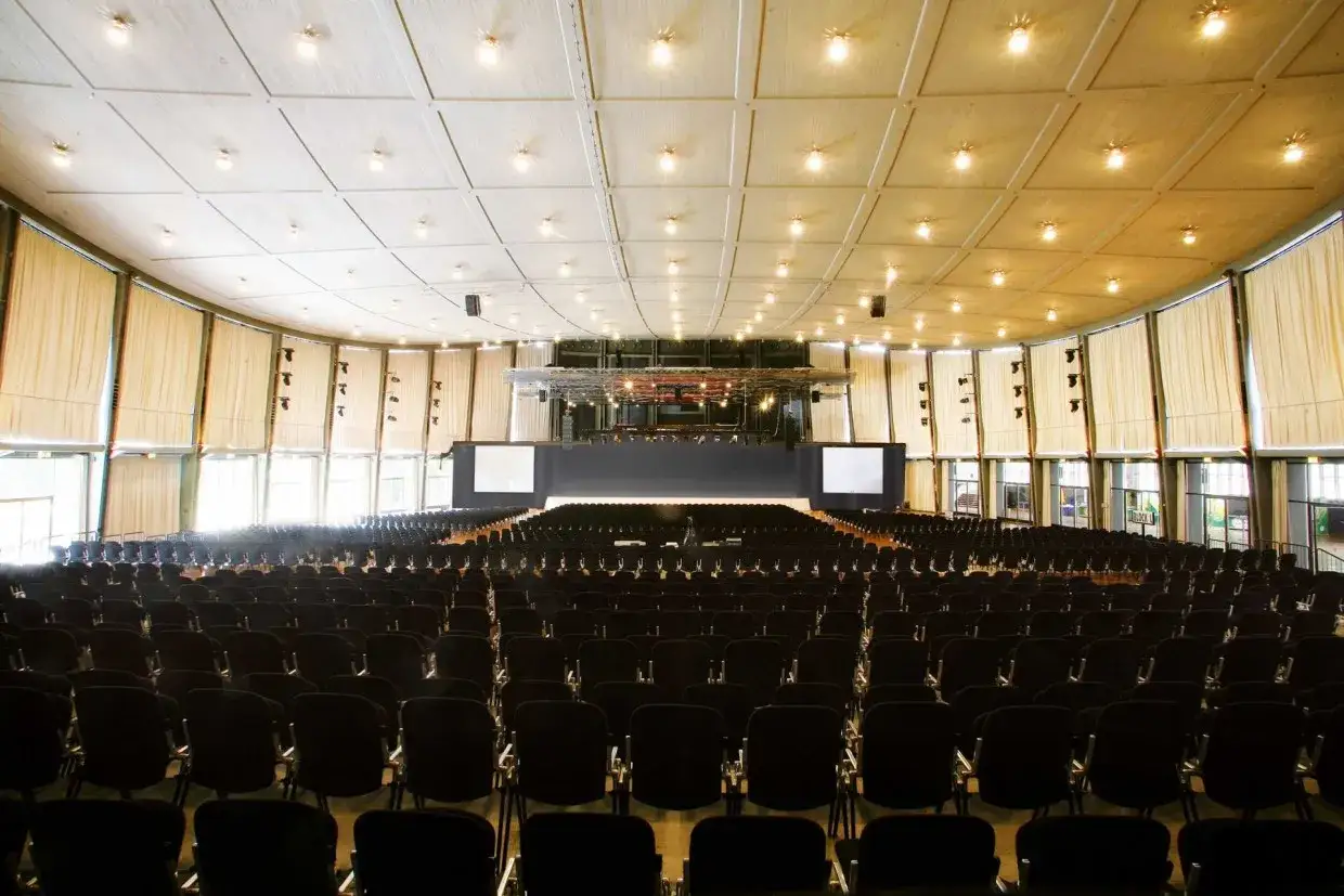 Gro&szlig;er, leerer Saal der Schwarzwaldhalle Karlsruhe mit vielen Reihen schwarzer St&uuml;hle, bereit f&uuml;r eine Veranstaltung.