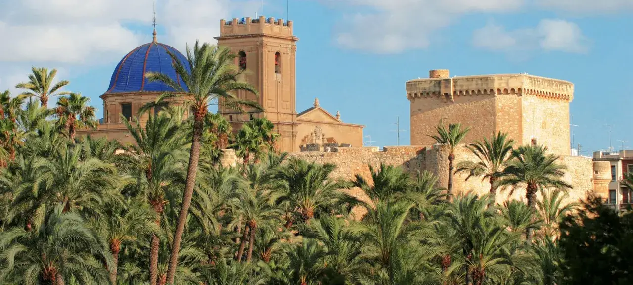 Palmeras exuberantes rodean la Basílica de Santa María y la fortaleza de Elche. ¡Mucho que ver!