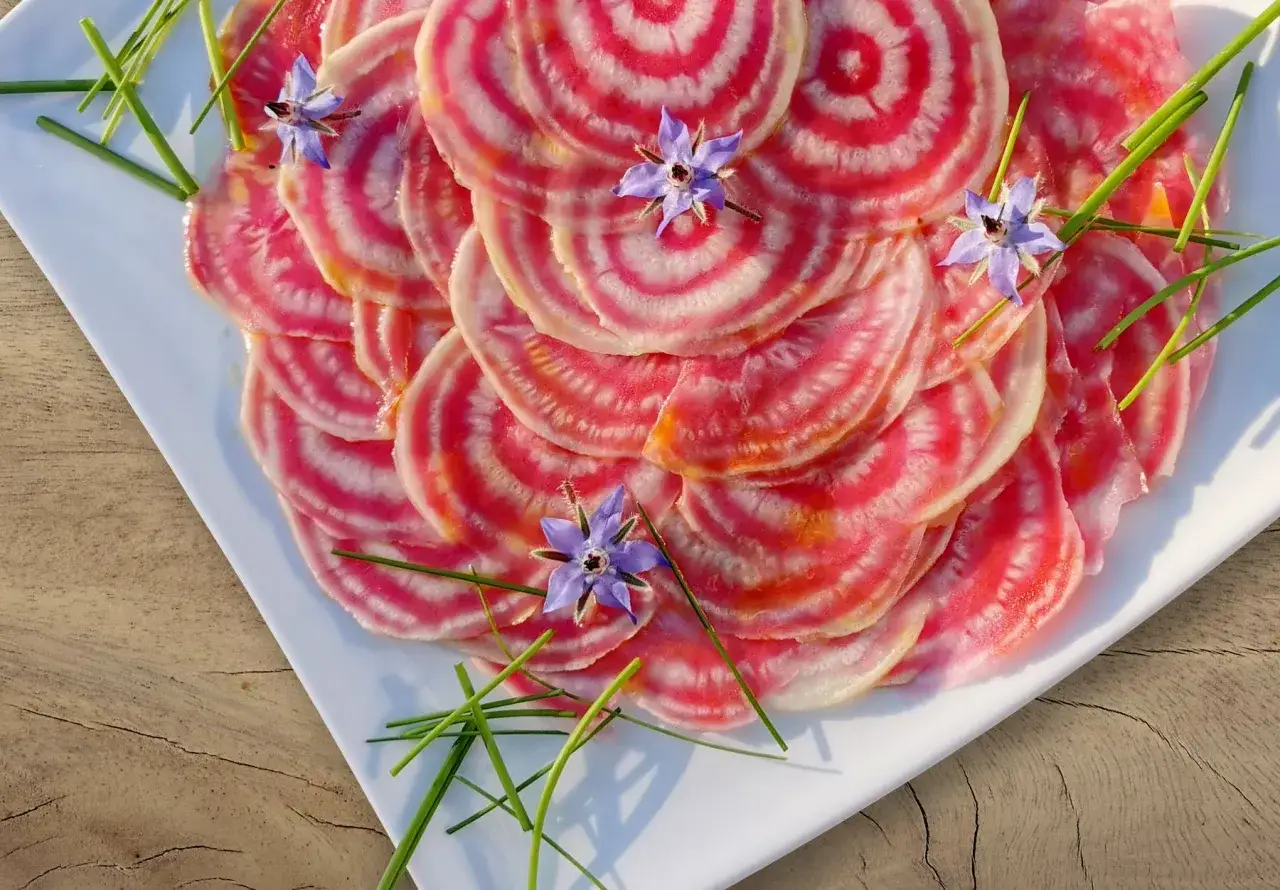 Bunte Ringelroten-Scheiben, garniert mit Borretschbl&uuml;ten und Schnittlauch. Ein optisch ansprechendes Gericht, das Lust auf ein Ringelbete Rezept macht.