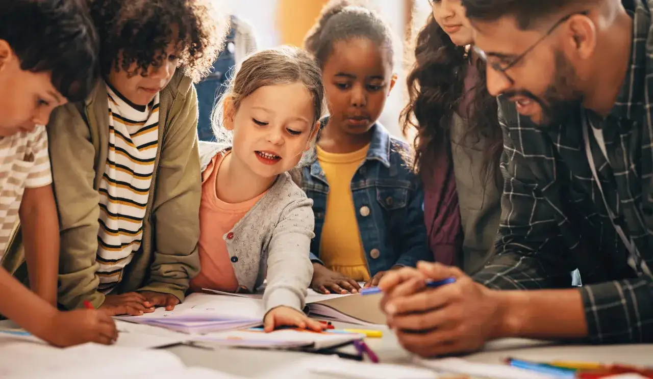 Lehrer und Kinder arbeiten gemeinsam an einem Projekt. Verschiedene Unterrichtsmethoden werden hier lebendig.