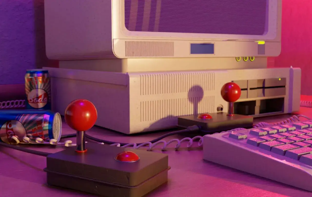 Nostalgiczne **gry retro** na starym komputerze z joystickami i puszkami napoju.