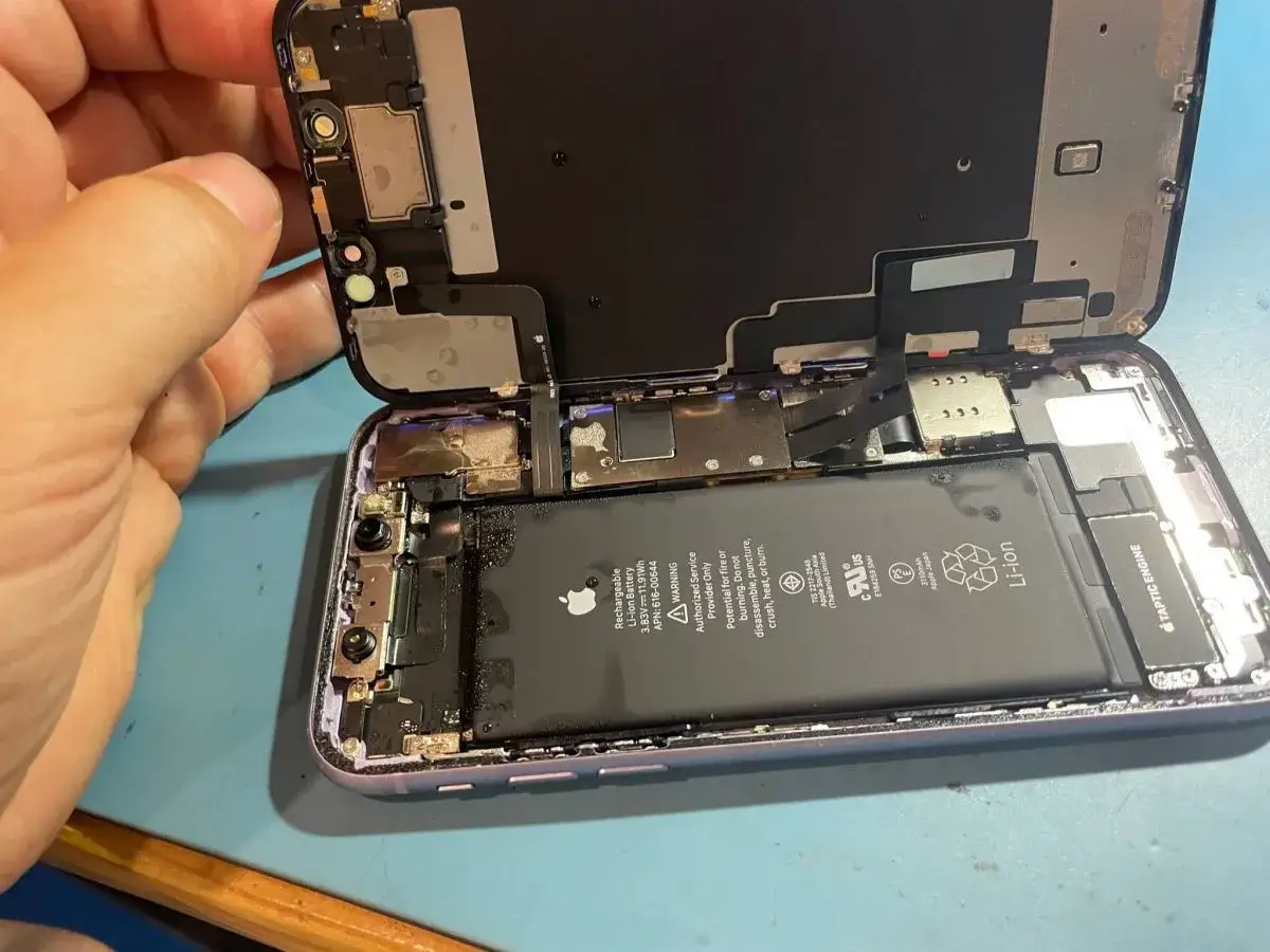 Otwarty telefon z widoczną baterią. Dowiedz się, jak wysuszyć telefon z wbudowaną baterią po zalaniu.