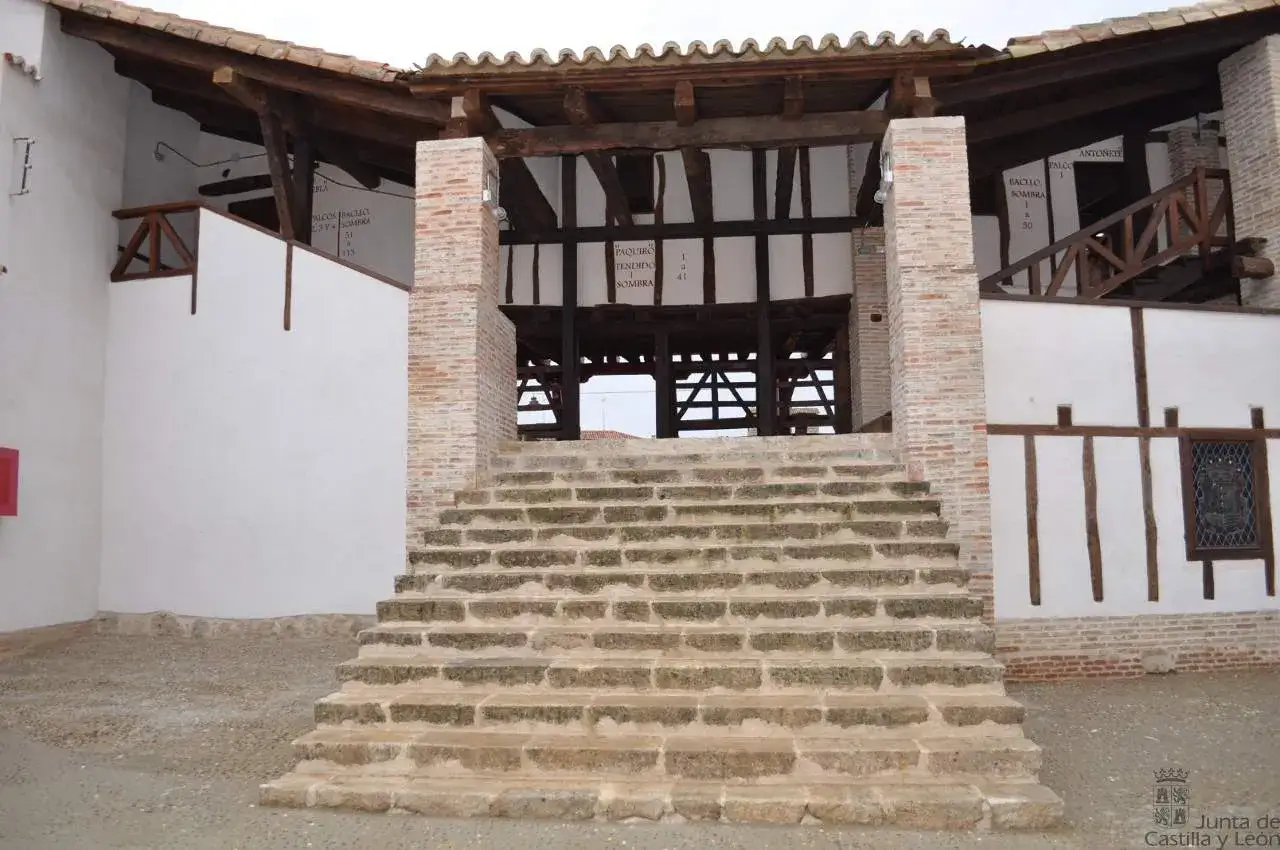 Escaleras de piedra conducen a la plaza de toros de Toro, con estructura de madera y ladrillo.