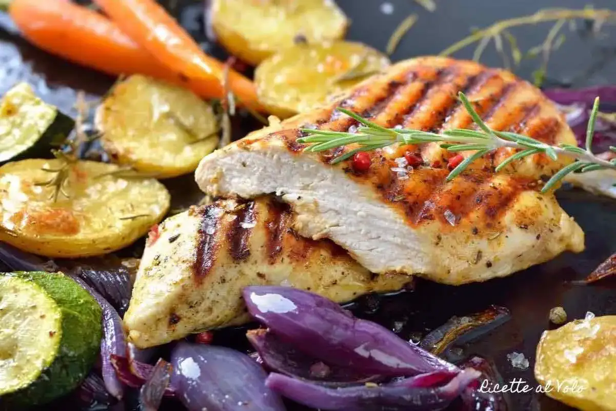 Petto di pollo grigliato con patate arrosto, carote, zucchine e cipolle rosse. Un'idea gustosa per le tue ricette con il petto di pollo.