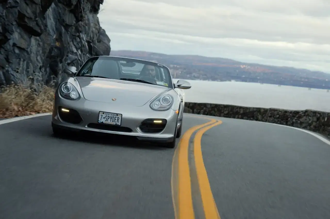 Silberner Porsche Boxster 987 Spyder auf kurviger Stra&szlig;e. Ein Blick auf die Wertentwicklung dieses Klassikers.