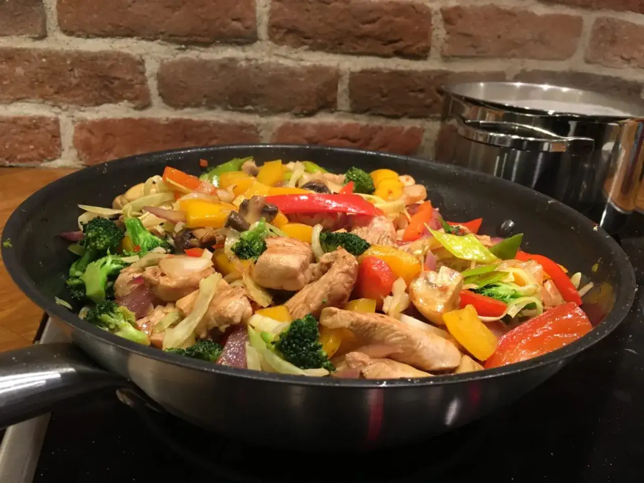 En färgsprakande wok med kyckling, broccoli, paprika och champinjoner. En härlig wokad kycklingrätt som ser utsökt ut.