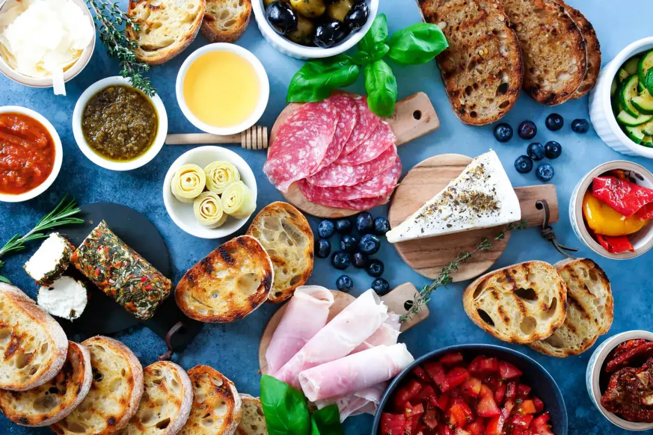 Eine k&ouml;stliche italienische Vesperplatte mit Salami, K&auml;se, Brot, Oliven und eingelegtem Gem&uuml;se.