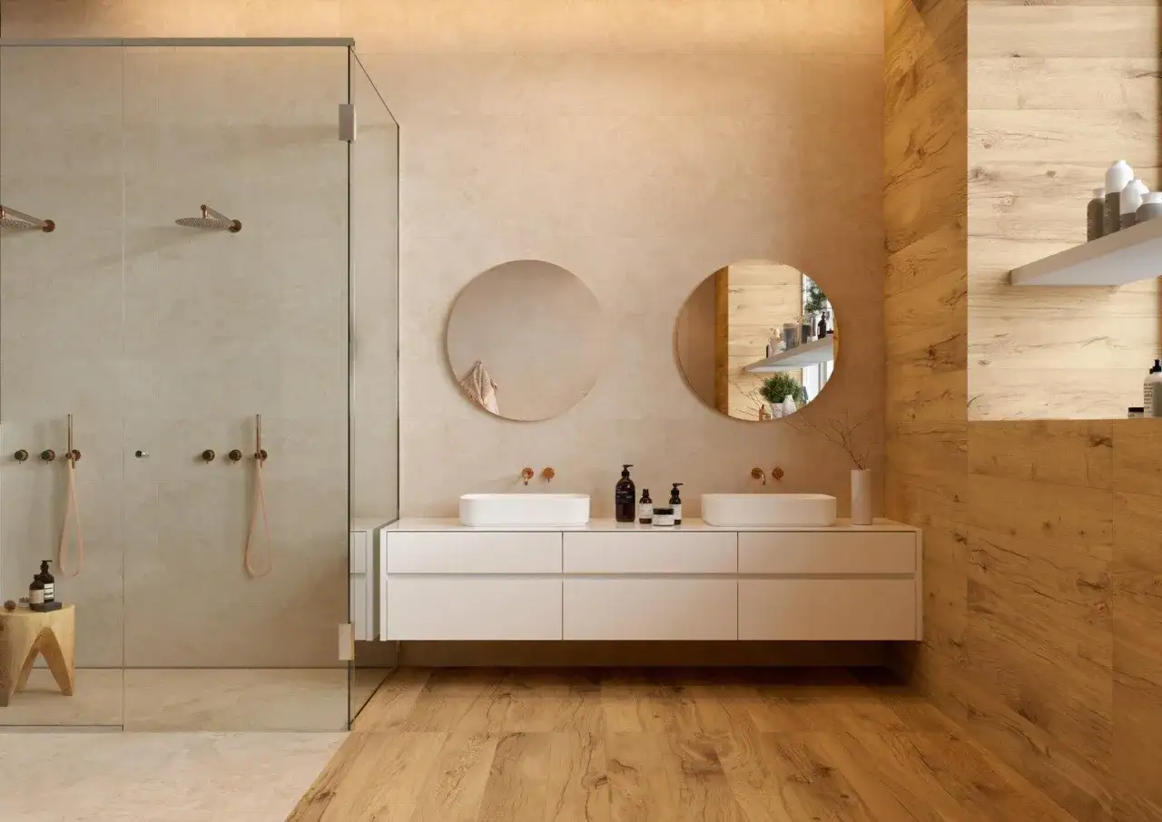 Bagno moderno con doccia in vetro, doppio lavabo e un perfetto abbinamento colori piastrelle bagno tra beige e legno.