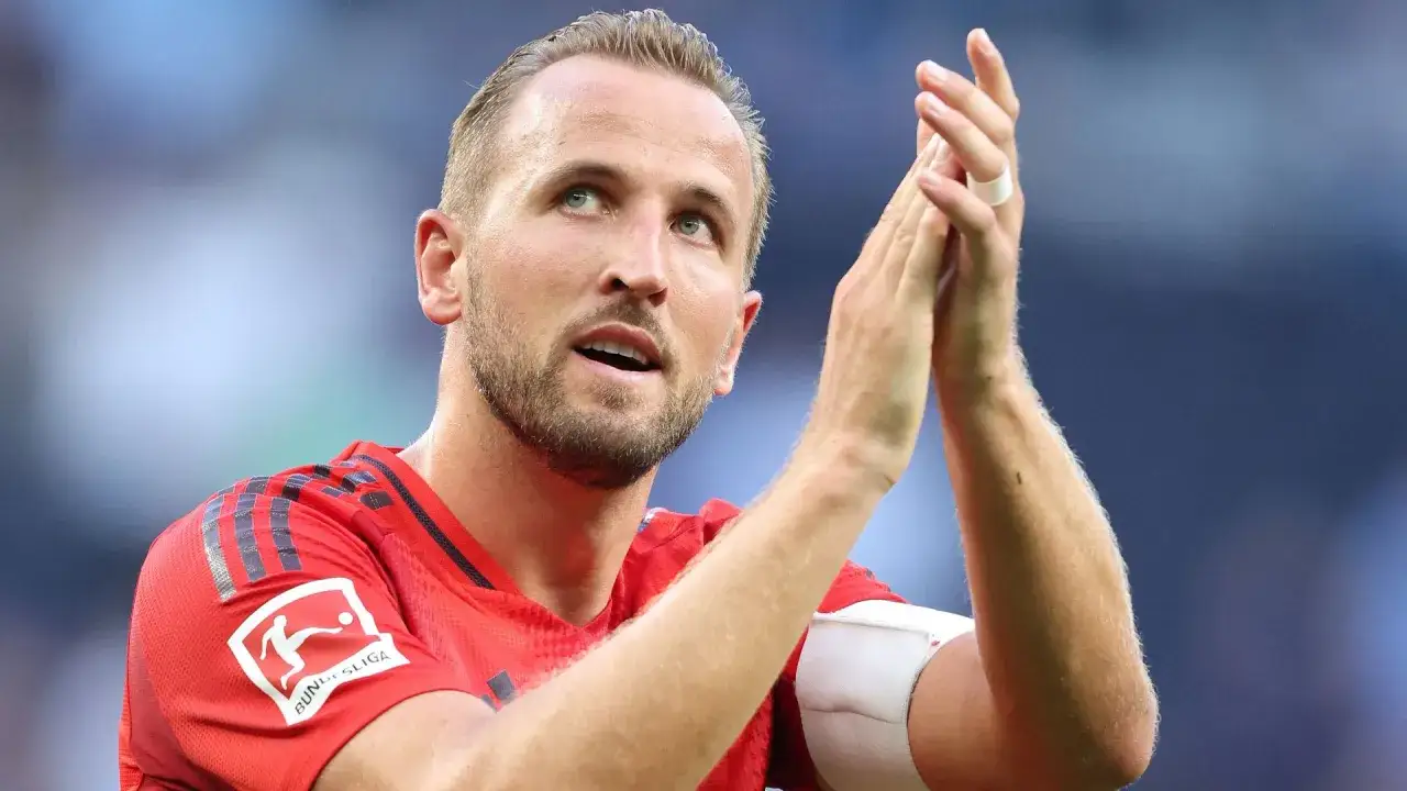 Harry Kane klatscht Beifall, sein Blick nach oben gerichtet. Er trägt das Trikot des FC Bayern München mit dem Bundesliga-Logo.