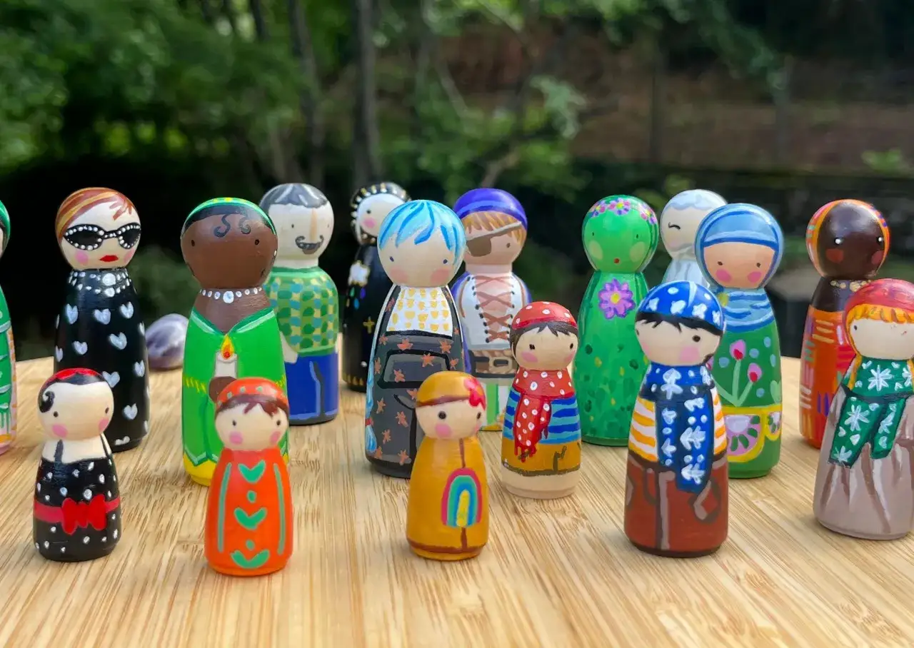 Figuras de madera pintadas, como si fueran personas, dispuestas en un c&iacute;rculo. Representan constelaciones familiares individuales, cada una con su propio dise&ntilde;o y color.