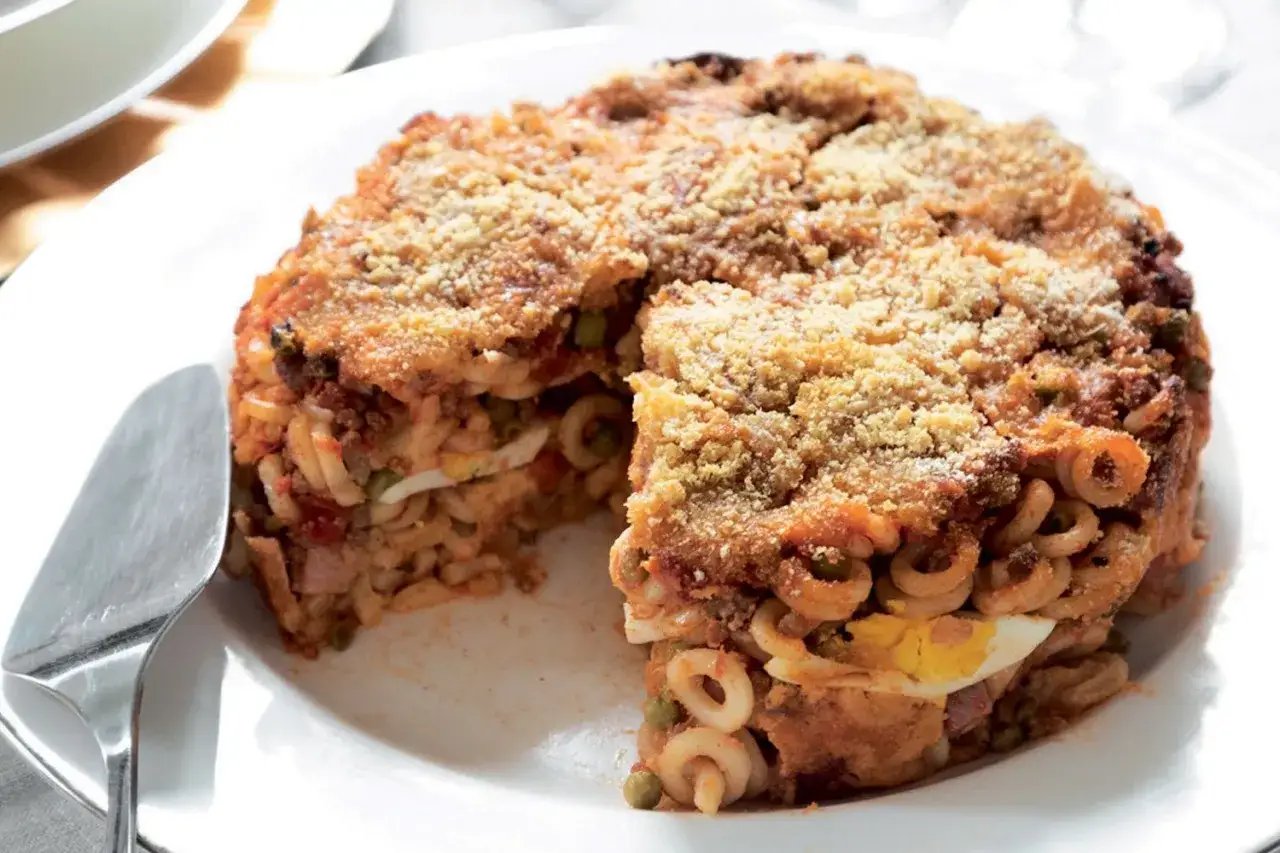 Timballo di anelletti alla palermitana ricetta originale: un tortino di pasta ricco di rag&ugrave;, piselli, uova sode e formaggio, con una croccante panatura dorata.