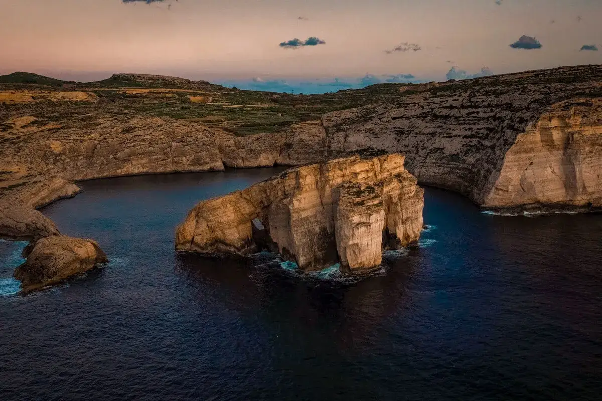 Felsformationen im Meer bei Sonnenuntergang. Ein unvergesslicher Urlaub in Malta, Erfahrungen wie diese prägen.