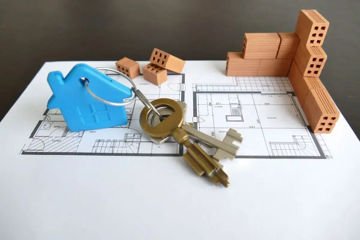 Clés et plan de maison avec des briques, symbolisant le projet de faire 2 emprunts pour achat immobilier.