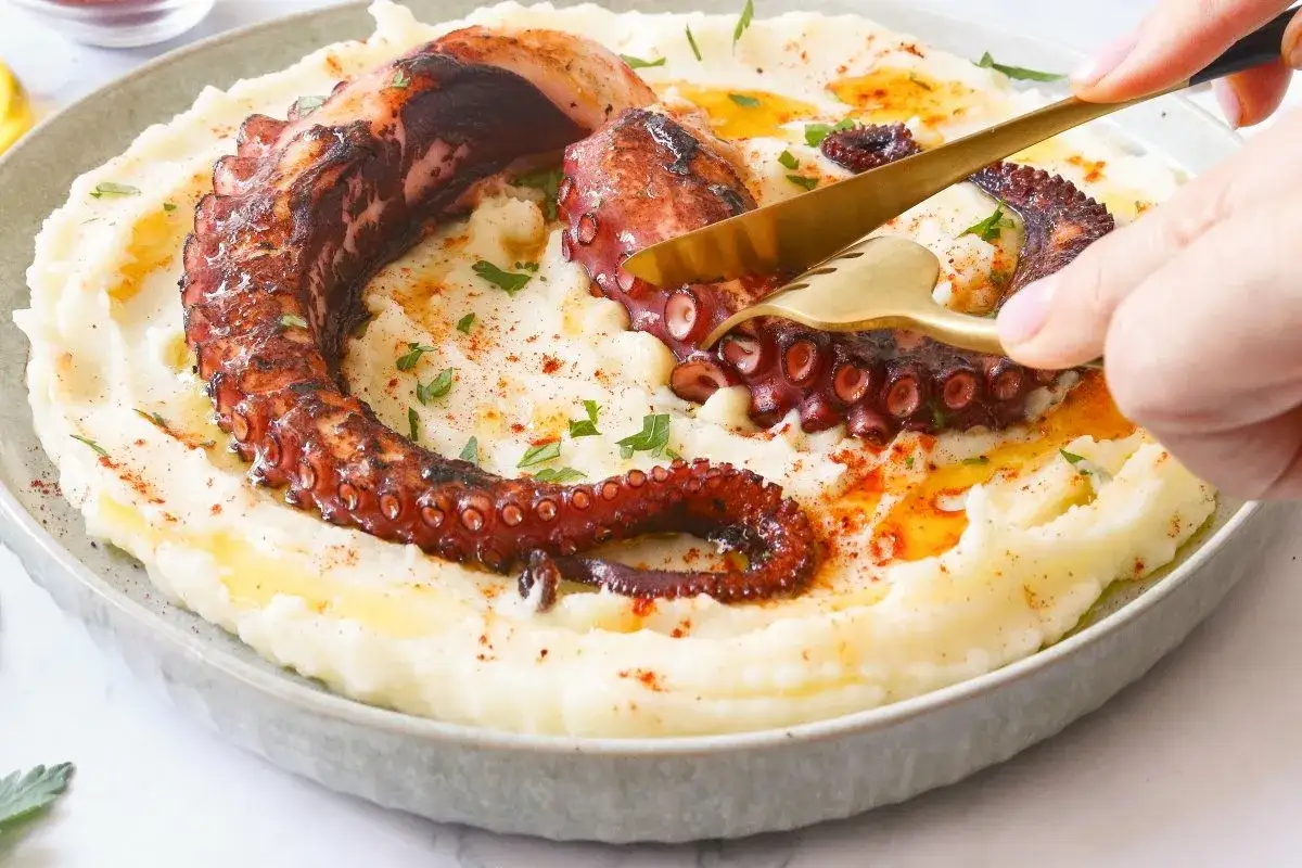 Un delicioso pulpo a la brasa, con tent&aacute;culos crujientes y tiernos, servido sobre un pur&eacute; cremoso.