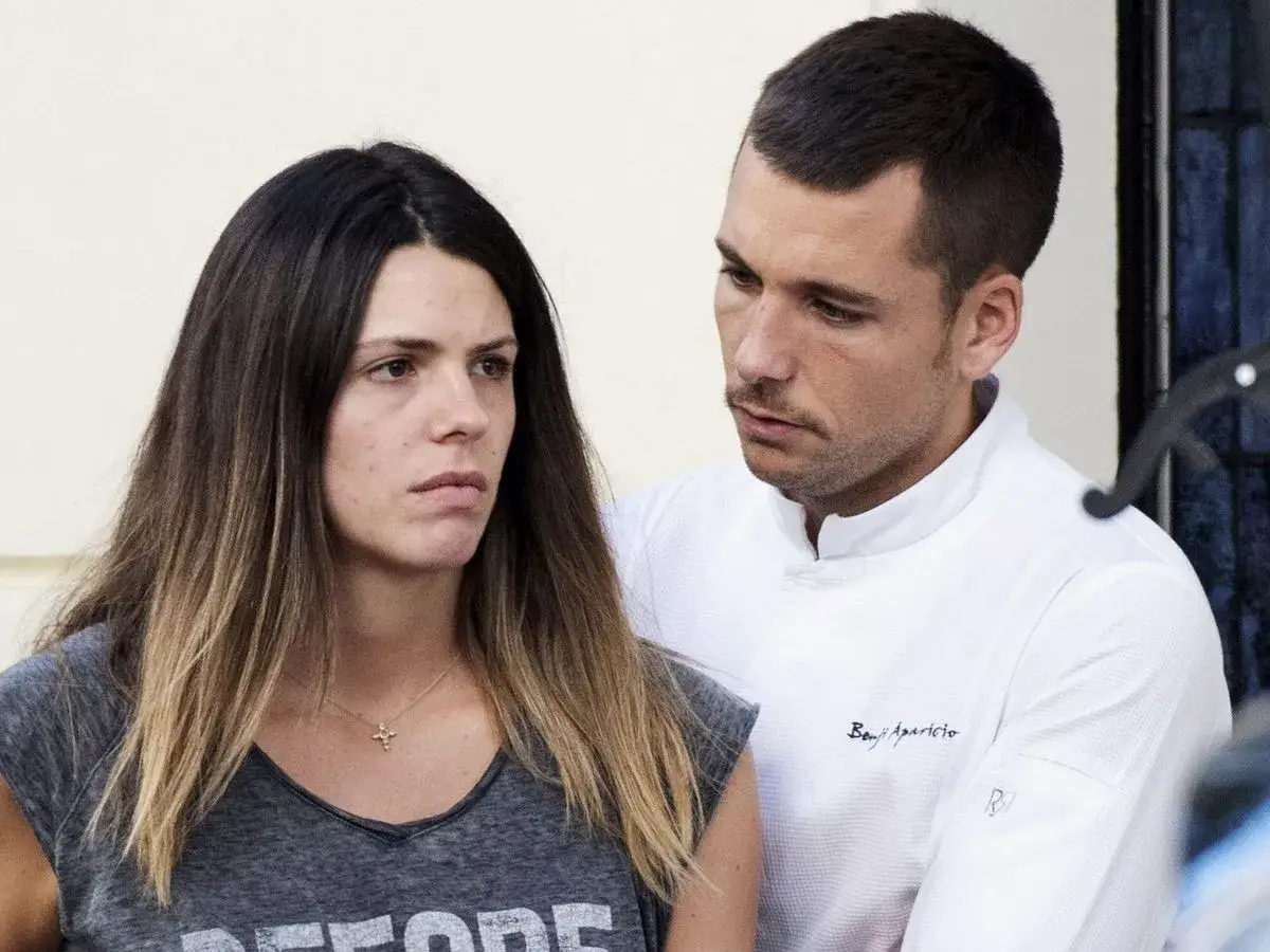 Laura Matamoros y Benji, con una mirada seria, comparten un momento de tensi&oacute;n. &Eacute;l, con su uniforme, parece ofrecerle apoyo.