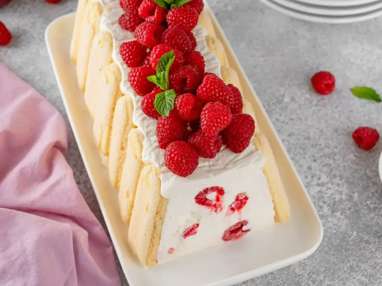 Prosty sernik z serka mascarpone, udekorowany malinami i miętą. Wygląda pysznie!