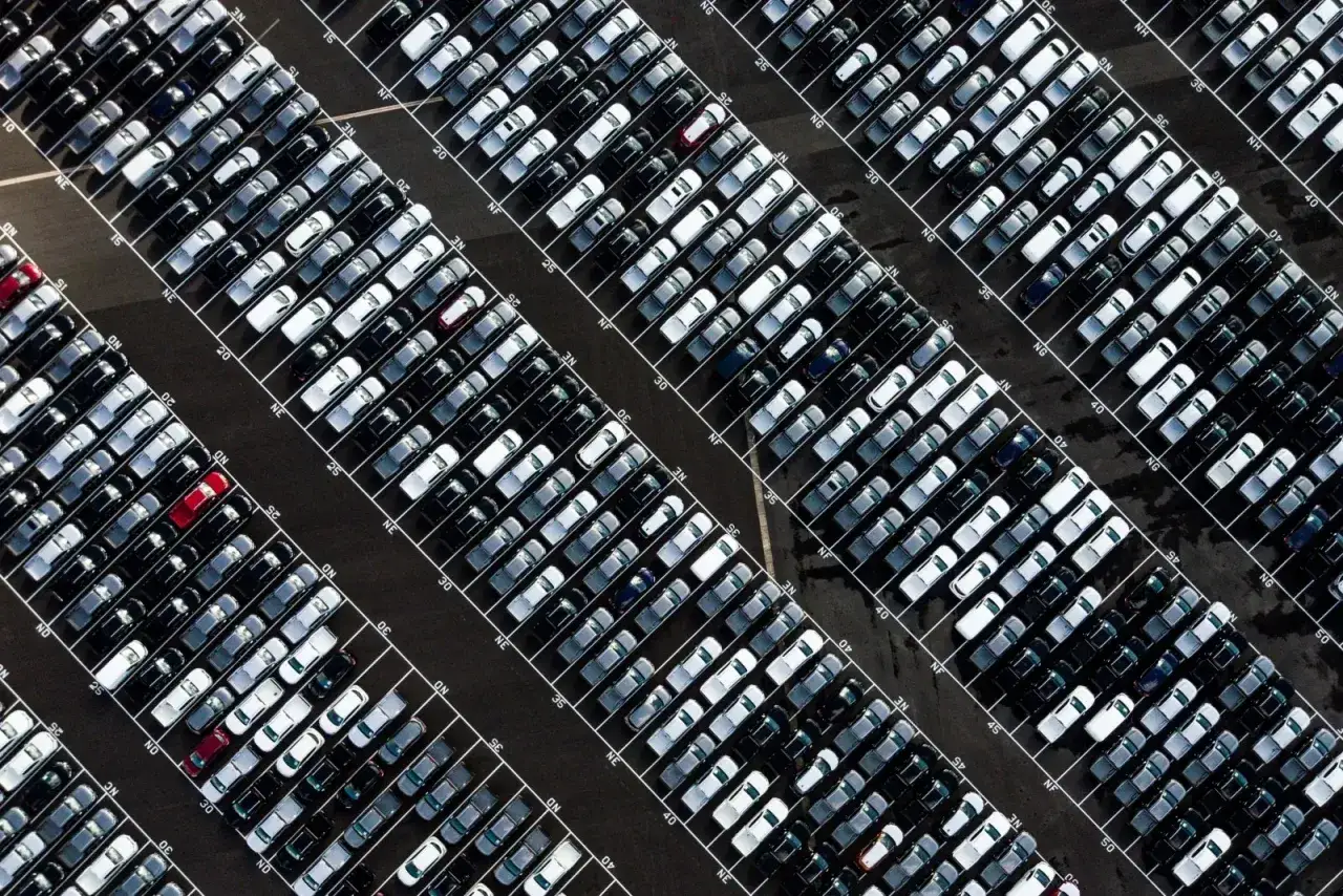 Ogromny parking pełen nowych aut, gotowych do odbioru. Zastanawiasz się, jak kupić auto w Niemczech? To miejsce może być początkiem Twojej podróży.