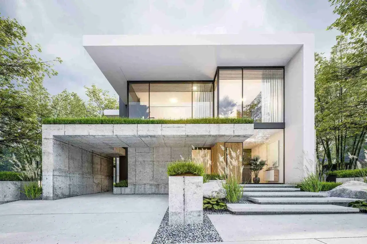 Casa moderna con acabados de fachadas en concreto y vidrio, rodeada de vegetaci&oacute;n exuberante.