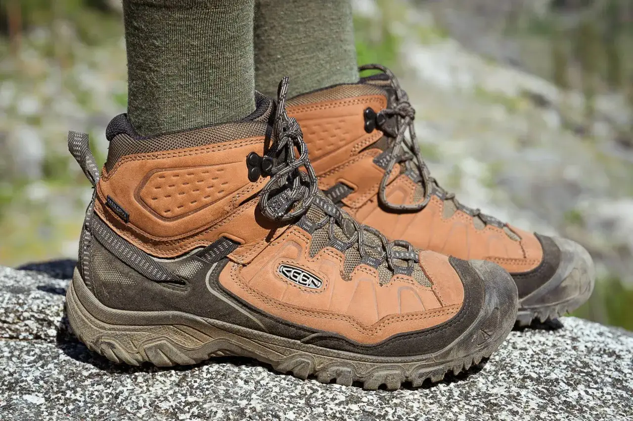 Brown hiking boots with green socks, showing how hiking boots fit snugly for comfort and support on the trail.