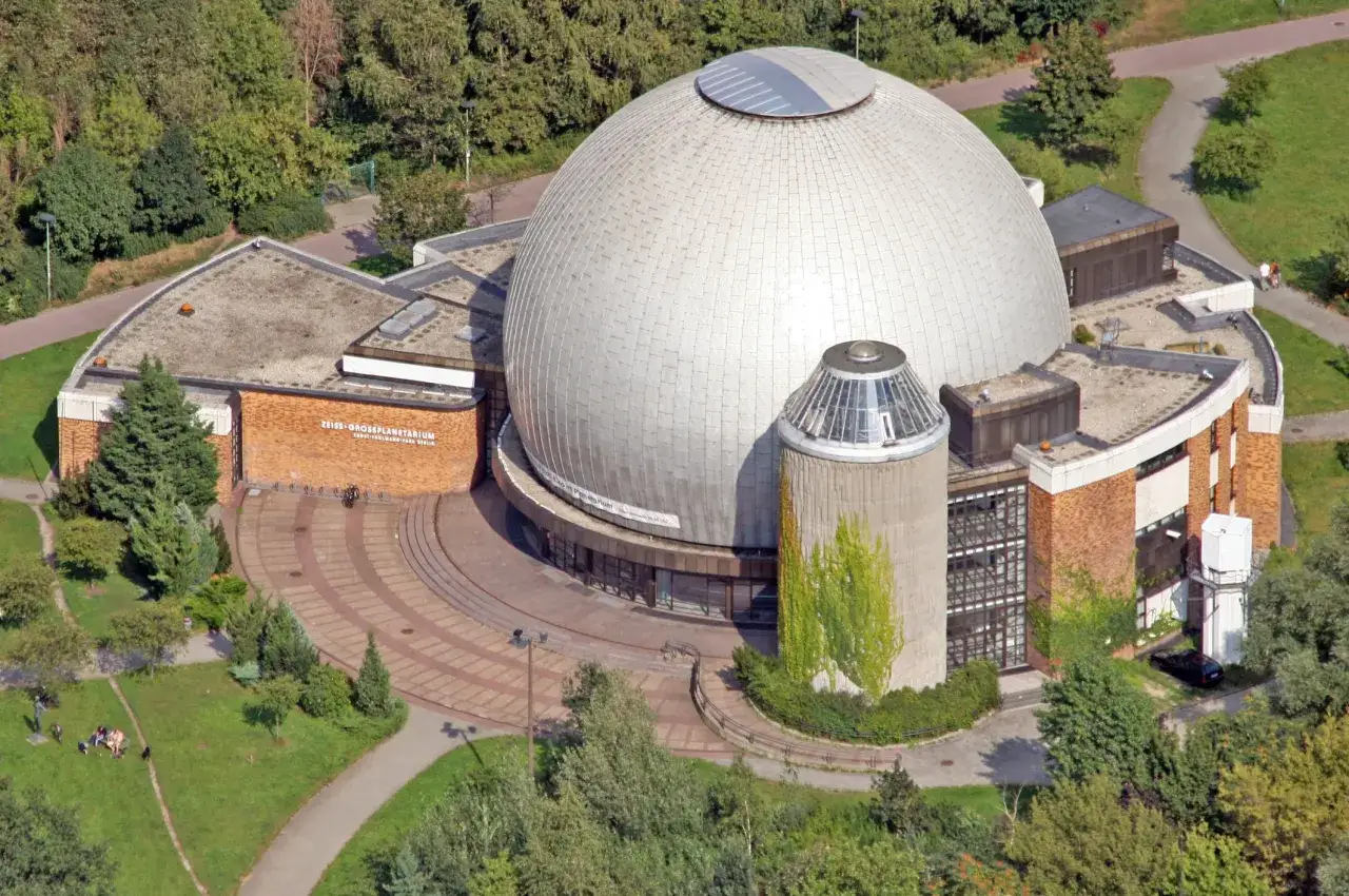 Das Zeiss-Gro&szlig;planetarium Berlin, eine Kuppel inmitten von Gr&uuml;n, l&auml;dt zur Sternenreise ein.