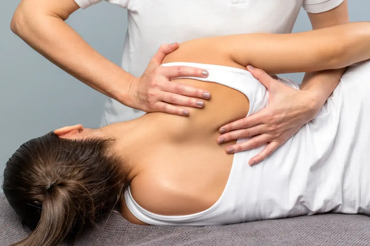 Physiotherapeut behandelt Schulterblatt. Bei einem nerv im schulterblatt eingeklemmt was tun? Hier wird sanft mobilisiert.