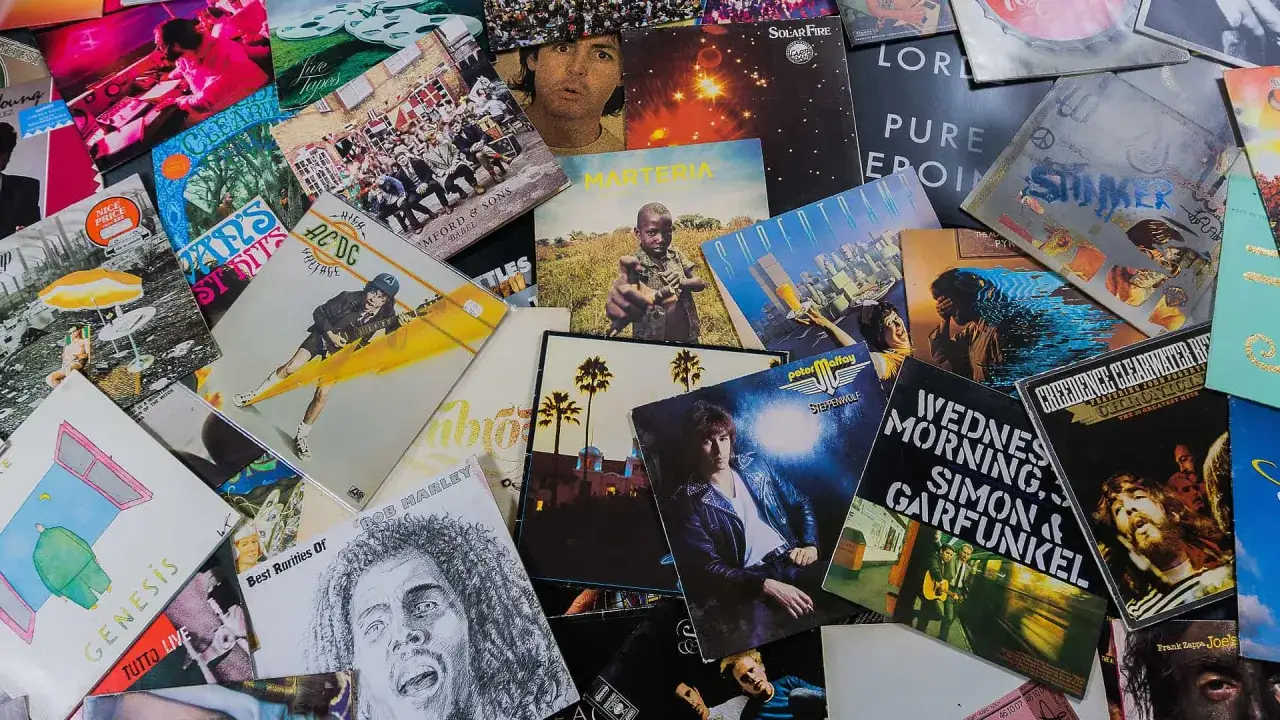 Bunte Schallplatten-Cover: AC/DC, Genesis, Bob Marley, Simon & Garfunkel. Wie nennt man Musik ohne Gesang? Instrumentalmusik!