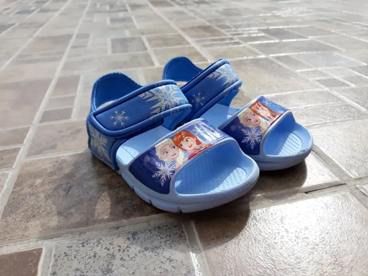 Niebieskie sandałki z Elsą i Anną, idealne jako buty do pływania dla małej fanki Krainy Lodu.
