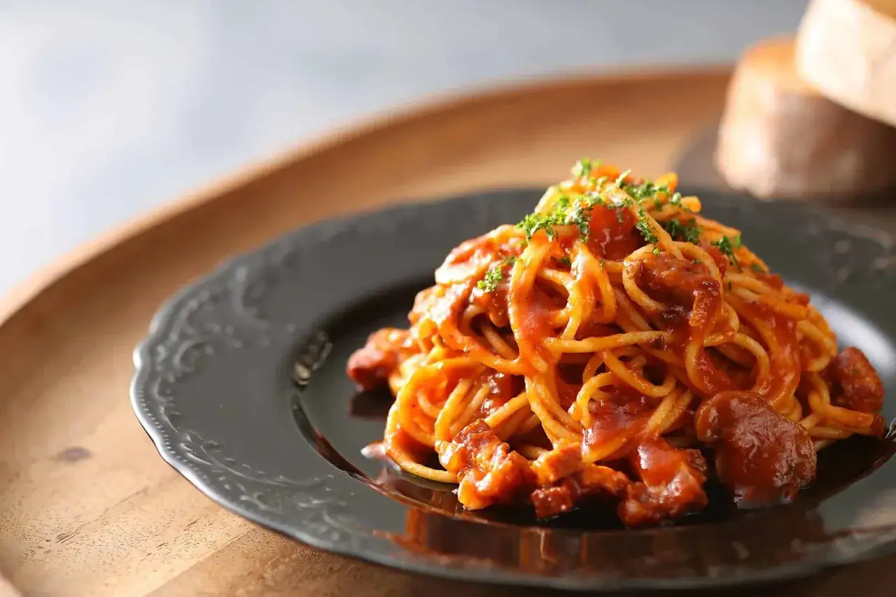 Un plat italien de p&acirc;tes spaghetti g&eacute;n&eacute;reusement napp&eacute;es d'une sauce tomate riche et garnies de persil frais.