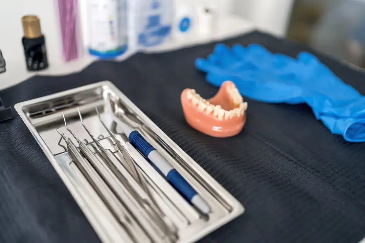 Zestaw stomatologiczny: narzędzia, model szczęki, rękawiczki. Gotowość do pracy nad protezą acetalową.