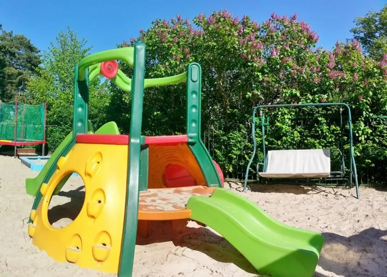 Kolorowy plac zabaw i huśtawka w piasku, idealne miejsce na wczasy nad morzem w Irena domki letniskowe.