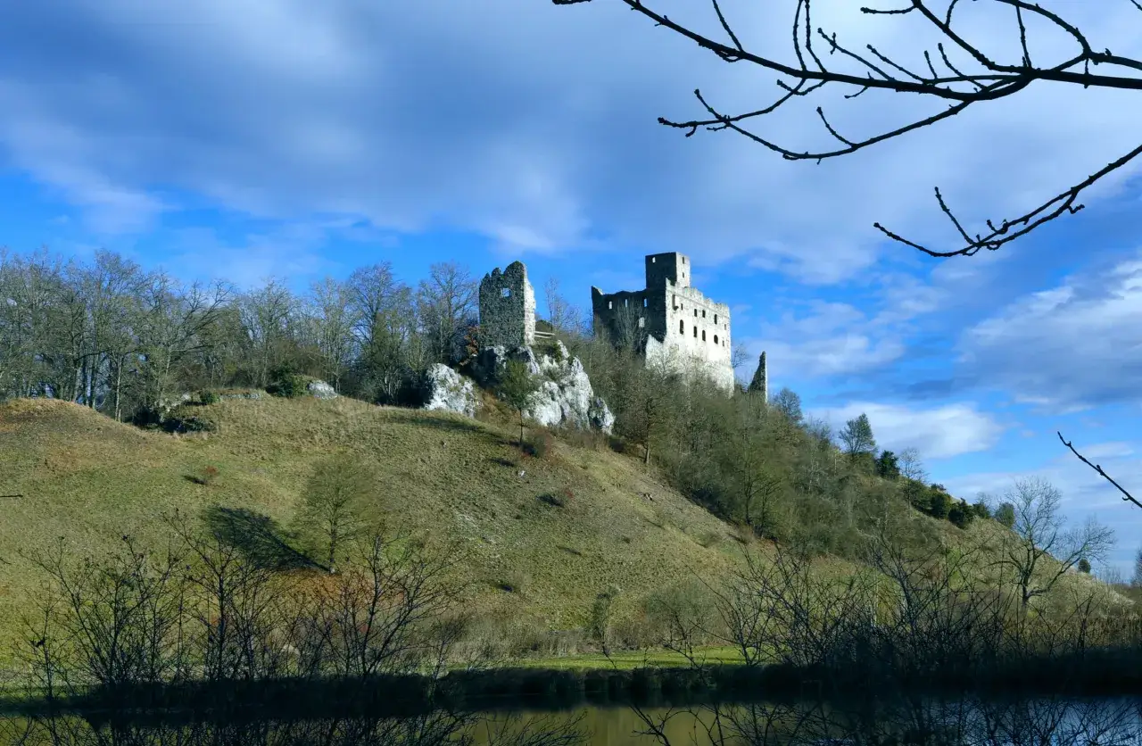 Die Burgruine Niederhaus thront auf einem felsigen Hügel unter blauem Himmel.