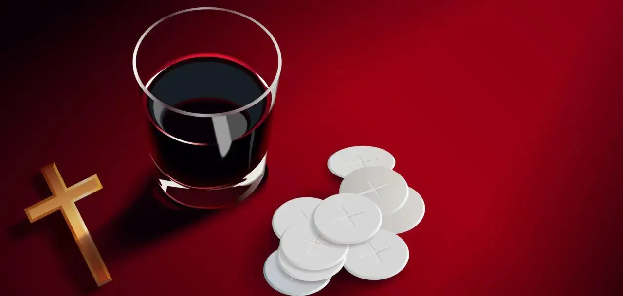 A golden cross, a glass of dark red wine, and communion wafers are arranged on a red background, symbolizing the sangre de cristo.