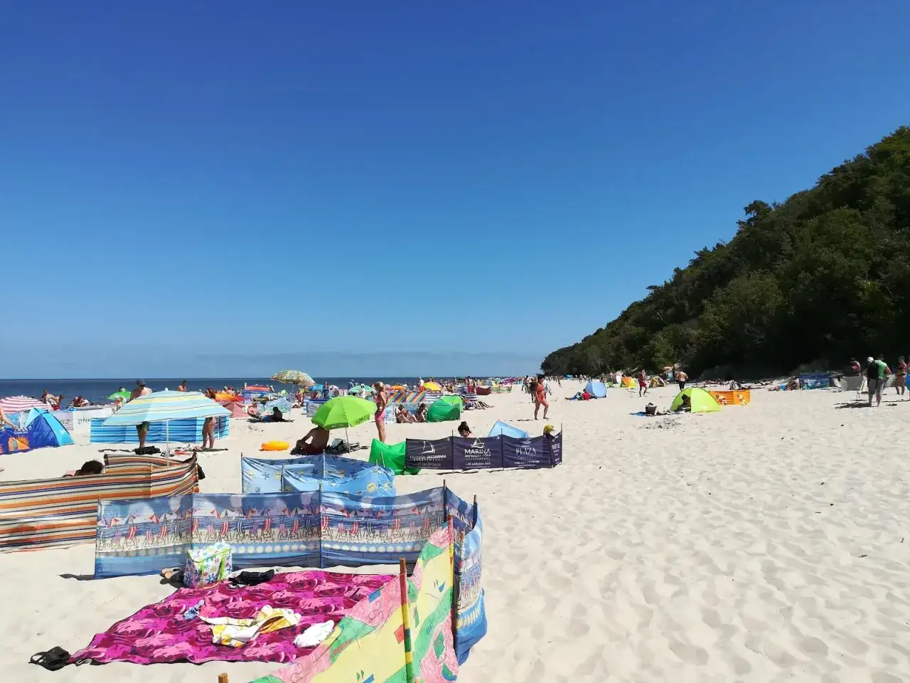 Słoneczna plaża we Władysławowie, Jastrzębia G&oacute;ra. Tłumy plażowicz&oacute;w, kolorowe parawany i namioty na piasku.