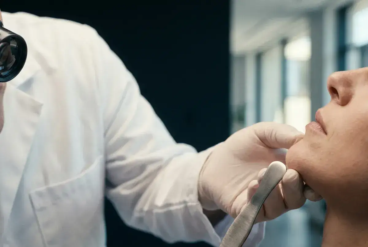 Medico con lente d'ingrandimento esamina un dente scheggiato.