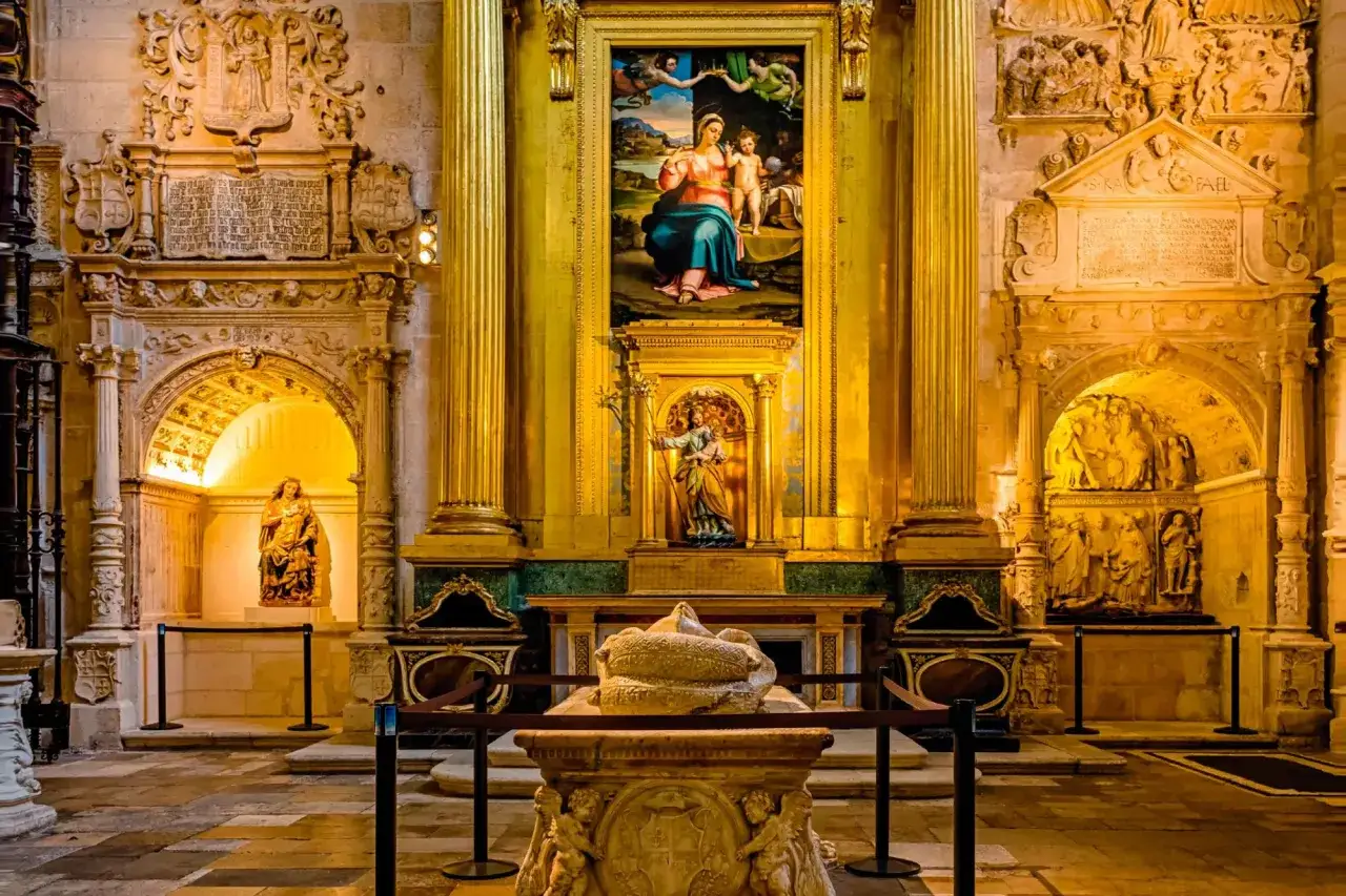 Interior de la Catedral de Burgos: tumba, retablo dorado con pintura de la Virgen y el Niño, y esculturas. Imprescindible que ver en la Catedral de Burgos.