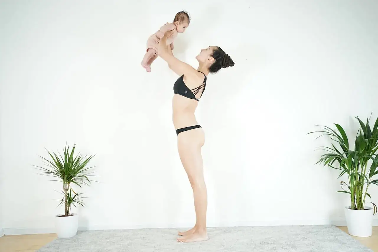 Donna in bikini solleva il suo neonato. Un momento di gioia e intimit&agrave;, che anticipa il ritorno alla vita di coppia e al sesso dopo il parto.