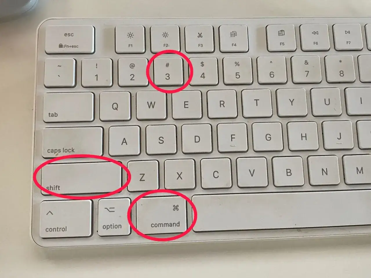Klawiatura z zaznaczonymi klawiszami Shift, Command i 3. Tak zrobisz screena na laptopie.
