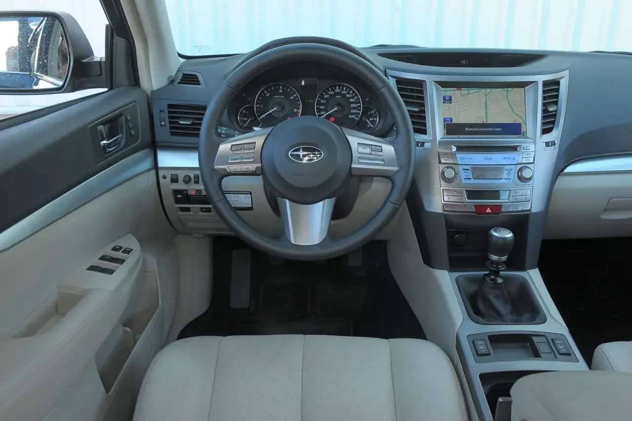 Wnętrze Subaru Outback 2025: kierownica, deska rozdzielcza z nawigacją i ekranem multimedialnym, dźwignia zmiany biegów.