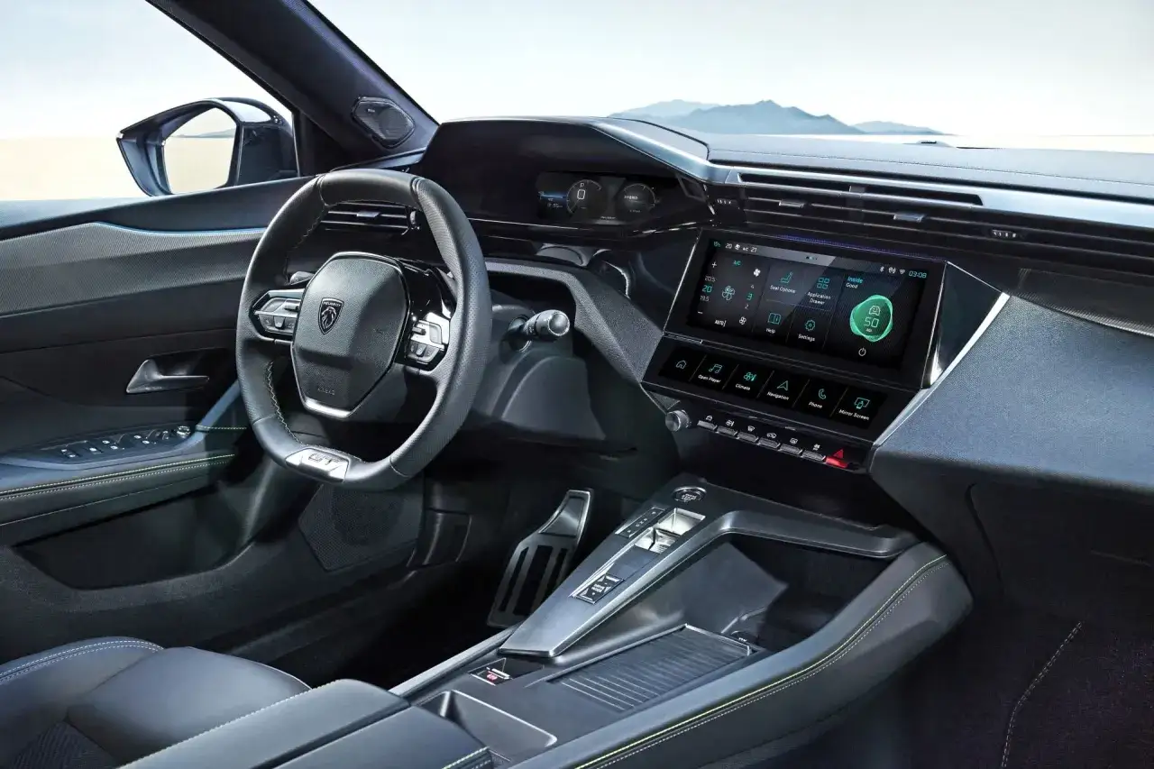 Nowoczesne **Peugeot 408 wnętrze** z dużym ekranem dotykowym, cyfrowymi zegarami i sportową kierownicą.