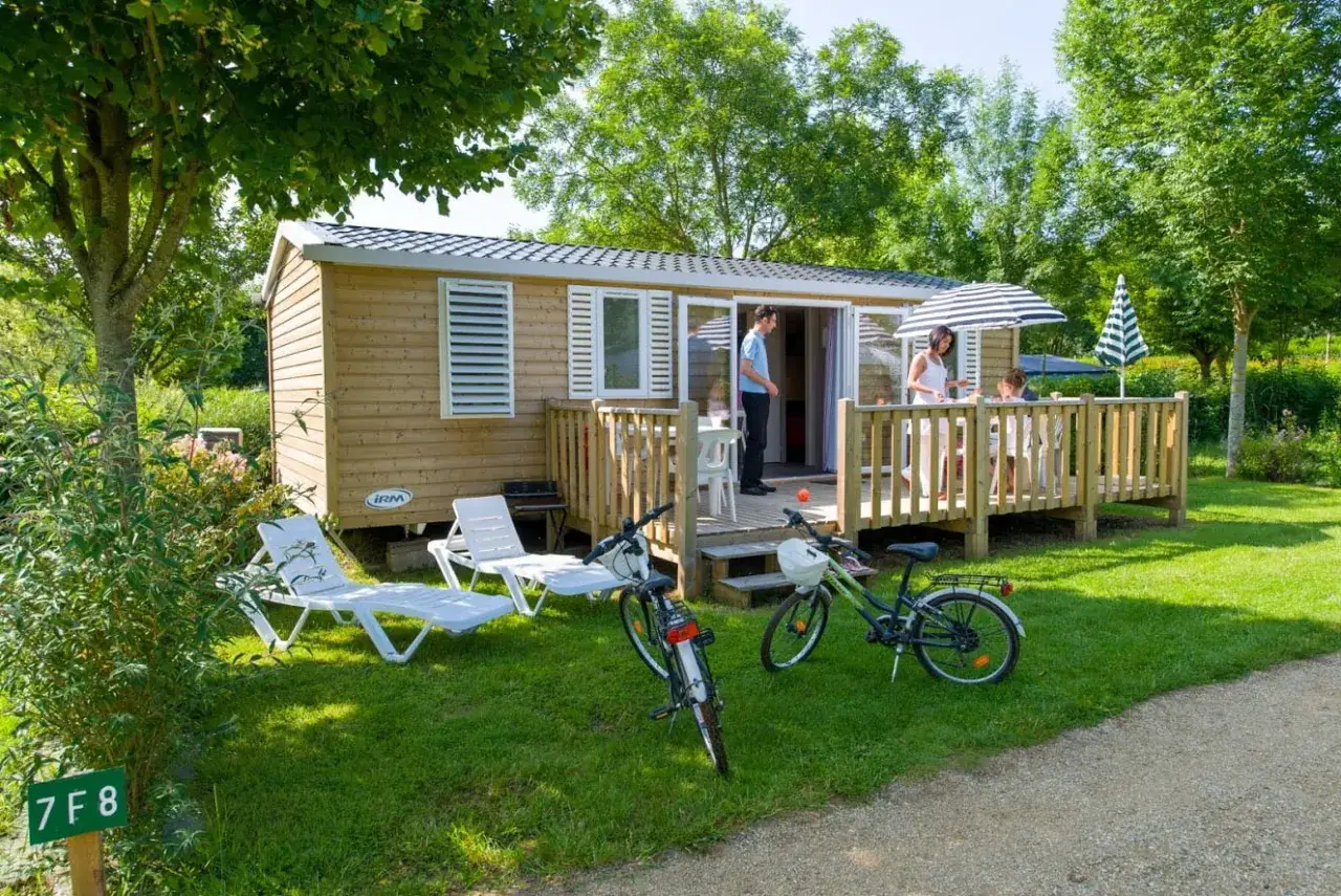 Famille profitant de l'extérieur de leur mobil-home, avec vélos et transats. Une scène paisible, loin des tracas de la jurisprudence mobil-home.