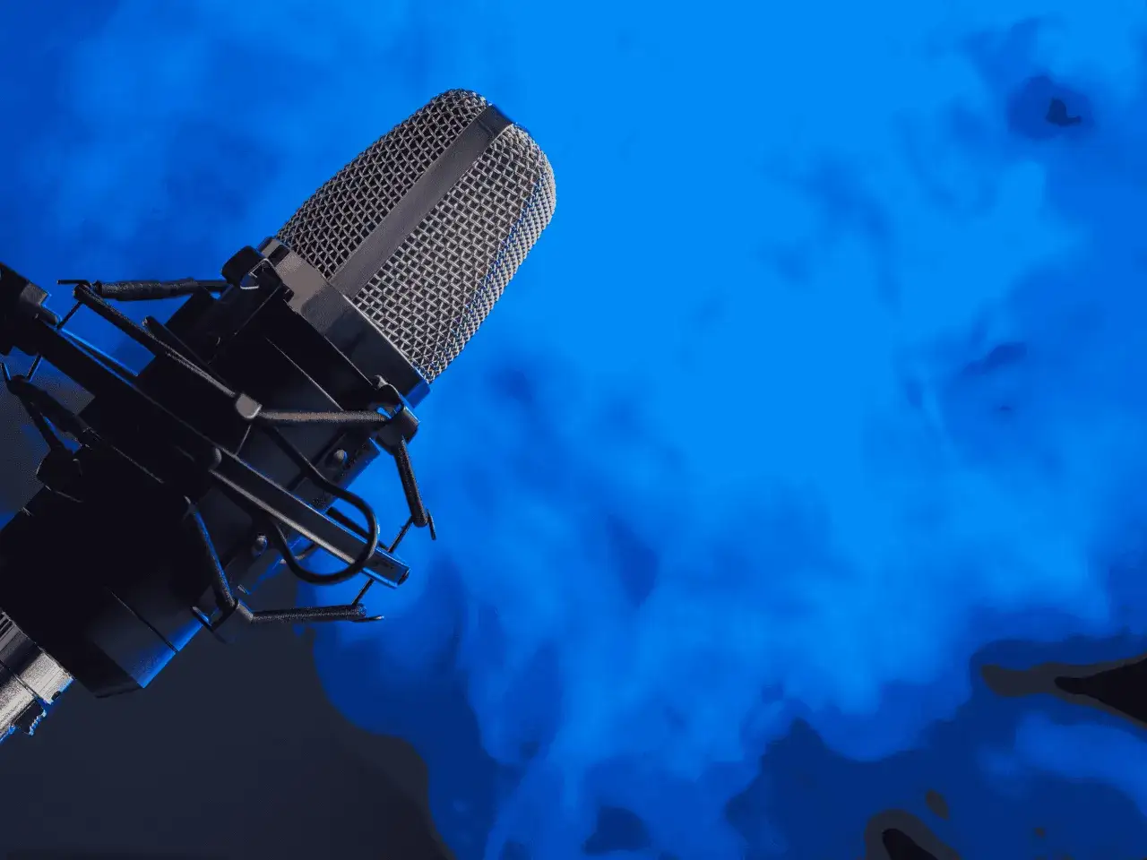 Profesjonalny mikrofon studyjny na tle niebieskiej mgły. Idealny do nagrywania podcastów, muzyki, a nawet porno z lektorem.
