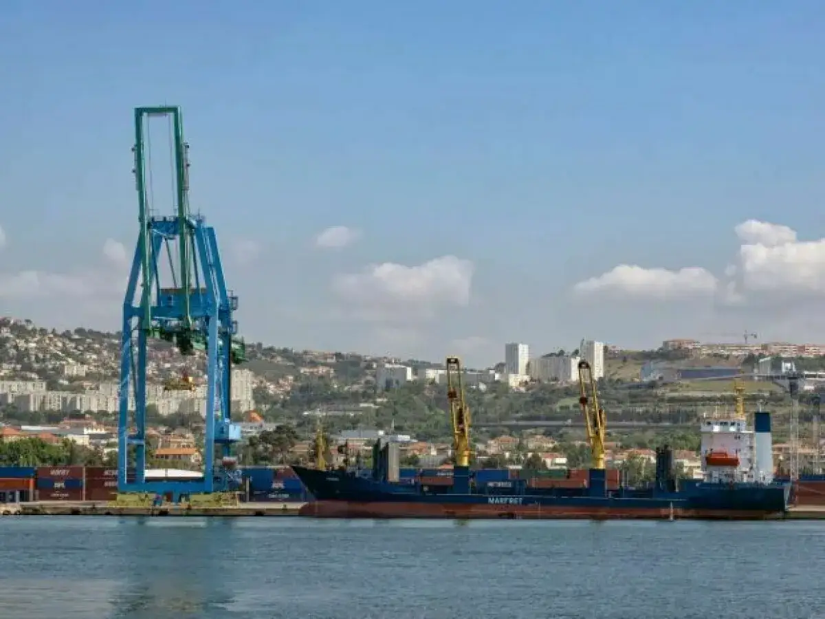 Ein großer Hafenkran belädt ein Frachtschiff in einem der größten Häfen Europas.
