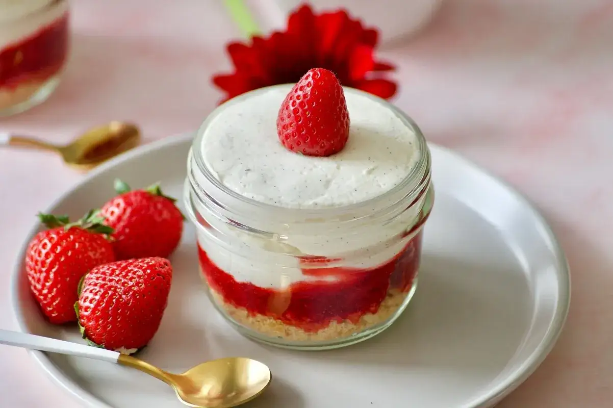 D&eacute;licieux tiramisu sans oeuf aux fraises, pr&eacute;sent&eacute; en pot avec une fraise fra&icirc;che sur le dessus.