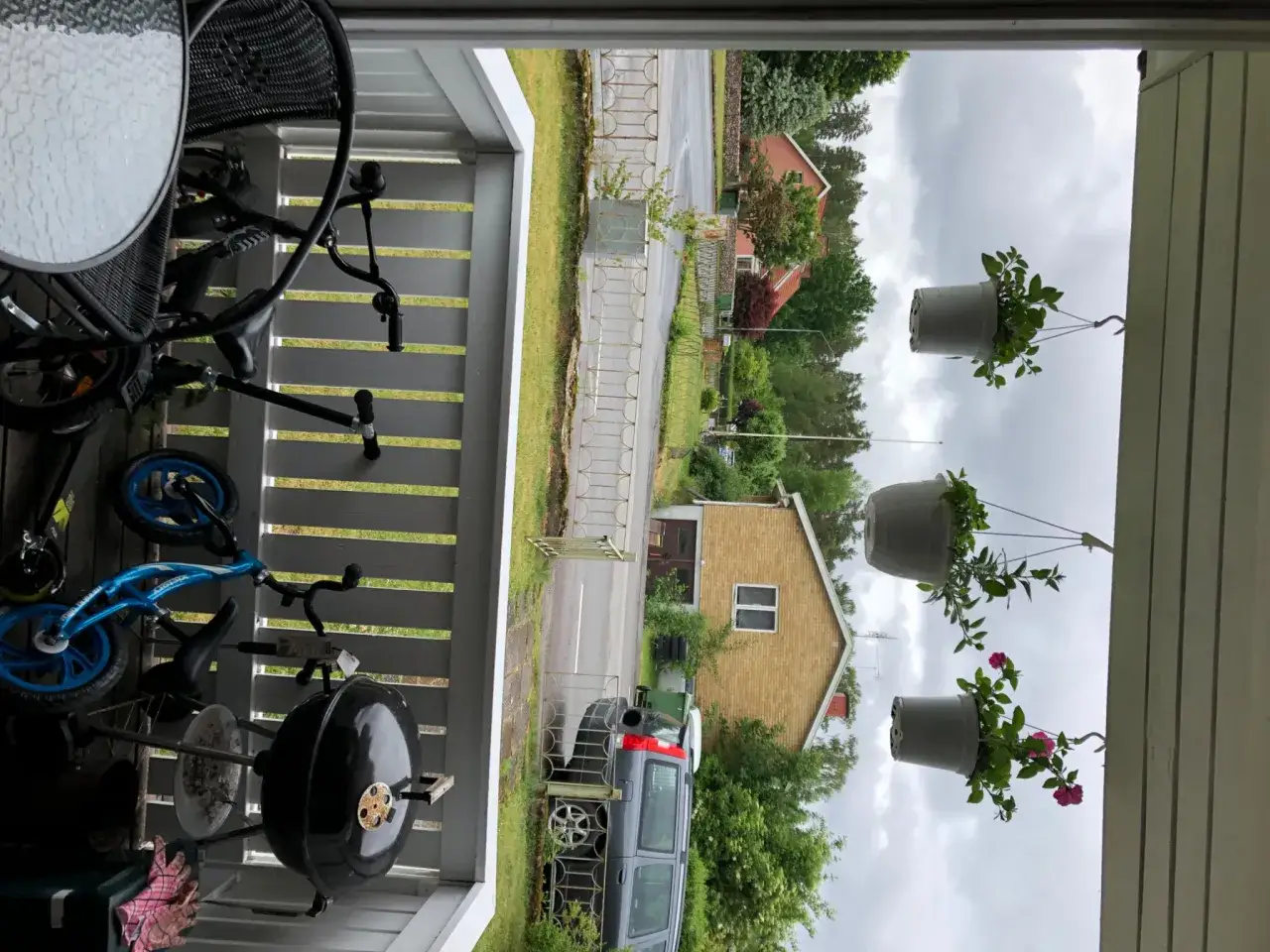 En gasolgrill under tak, redo för sommarens grillkvällar. Bredvid står en blå barncykel och en svart stol.