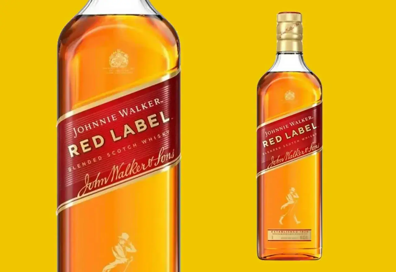 Dwie butelki whisky Johnnie Walker Red Label na żółtym tle. Klasyczny, rozpoznawalny design.