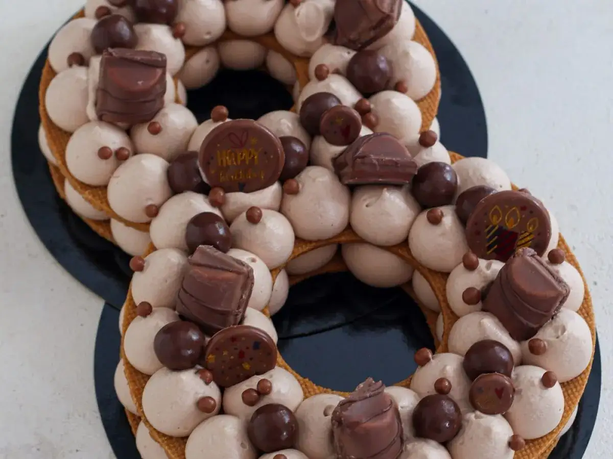 G&acirc;teau number cake chocolat, d&eacute;cor&eacute; de cr&egrave;me onctueuse, de chocolats et de billes croquantes. Parfait pour une recette number cake chocolat d'anniversaire.